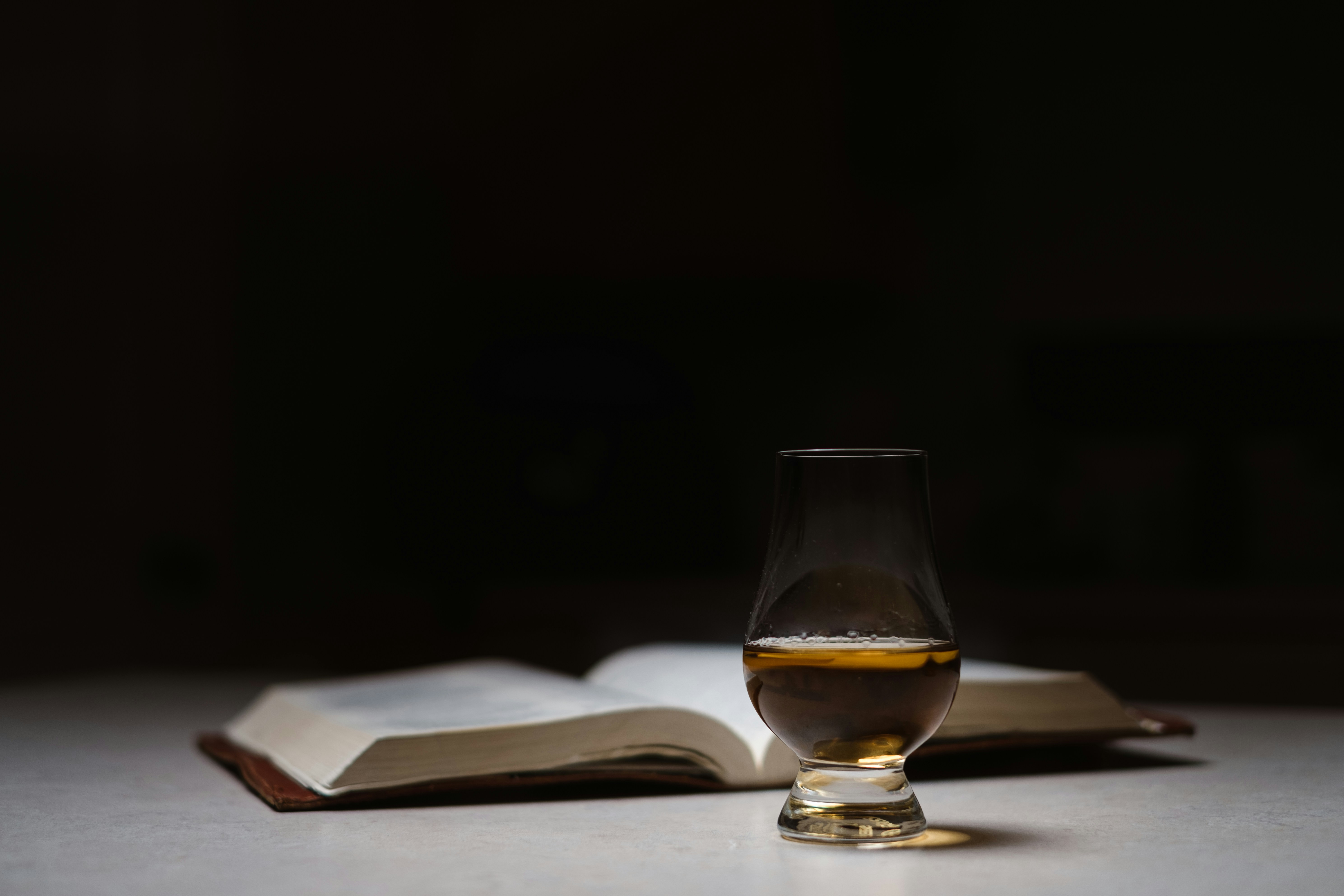 A dram of New Zealand craft whisky beside an open book